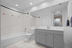 Full bath featuring vanity, shower / bath combination, light tile patterned floors, and recessed lighting