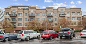 View of apartment building / complex with uncovered parking