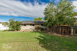 Rear view of house featuring a fenced backyard