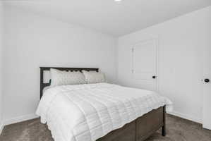 Bedroom featuring dark colored carpet