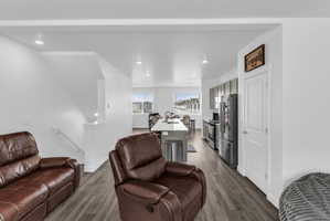 Living area with light wood-type flooring and recessed lighting