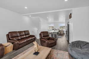 Living area with dark wood-style floors, recessed lighting, and beam ceiling