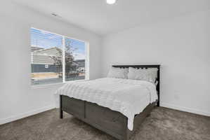 Bedroom featuring dark carpet