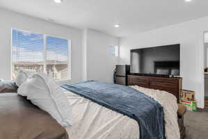 Bedroom with freestanding refrigerator, recessed lighting, and carpet