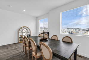 Dining room with dark wood finished floors and recessed lighting