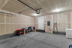 Garage with electric panel and fridge