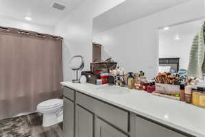 Bathroom featuring vanity, dark wood-style floors, and shower / bath combination with curtain