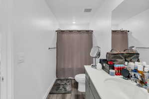 Bathroom with vanity, dark wood finished floors, and shower / tub combo with curtain