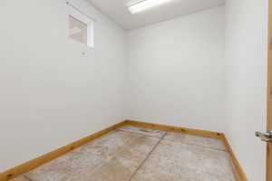 Unfurnished room with concrete flooring and baseboards