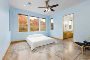Bedroom with concrete flooring, a ceiling fan, ensuite bathroom, and recessed lighting