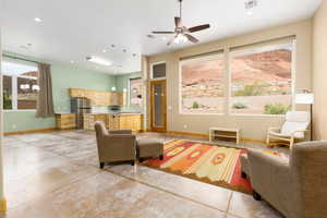 Living area with finished concrete flooring, hanging lights, and ceiling fan