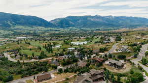 Aerial perspective of suburban area with a water and mountain view and a local golf course
