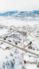 Snowy aerial view with a mountain view and a residential view