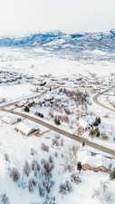 Snowy aerial view featuring a mountain view and a residential view