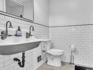 Stylish 3/4 bathroom with eye-catching subway tile and updated finishes, offering both function and personality for guests and lower-level living.