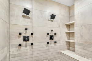 Designed as a private spa retreat, the primary bathroom features an expansive walk-in shower, and a serene atmosphere that brings comfort and luxury to daily living.
