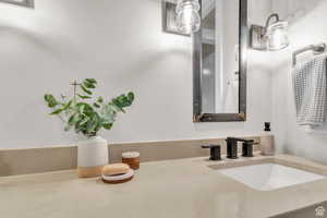 Guest bathroom with dual vanities and custom metal-framed mirrors by a local artist, blending functionality with distinctive design.