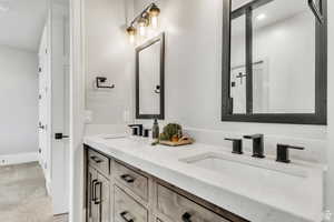 Jack-and-Jill bath with dual sinks and custom metal-framed mirrors by a local artist