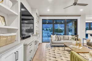 Central living room designed for comfort and connection, open to the kitchen and perfect for entertaining. Large windows frame stunning mountain views and lead to a covered deck for seamless indoor-outdoor living.