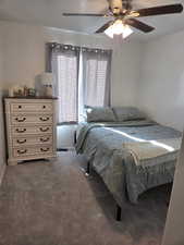 Bedroom with dark carpet and ceiling fan