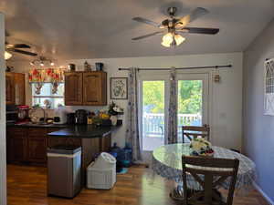 Kitchen featuring ceiling fan, dark countertops, dark wood-style floors, a peninsula, and a textured ceiling