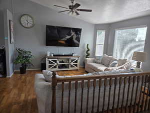Living room with ceiling fan and wood-type flooring