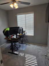 Office area featuring a ceiling fan, light carpet, and a textured ceiling