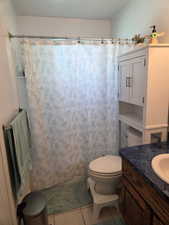 Bathroom featuring vanity, a shower with shower curtain, and light tile patterned flooring