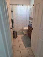Bathroom featuring light tile patterned floors, a shower with shower curtain, and vanity