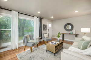 Living area with wood finished floors and recessed lighting