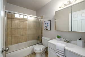 Full bathroom featuring vanity, bath / shower combo with glass door, and light tile patterned floors