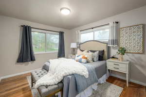 Bedroom featuring multiple windows and wood finished floors