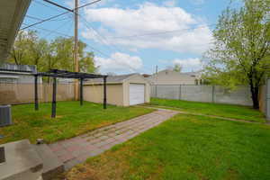Fenced backyard with an outdoor structure and a garage