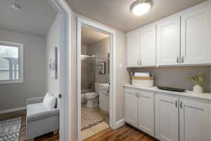 Bathroom with dark wood-style floors, vanity, a textured ceiling, and an enclosed shower