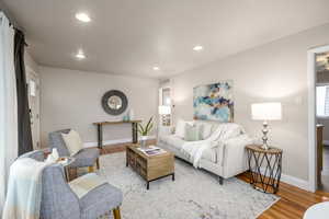 Living area with wood finished floors and recessed lighting