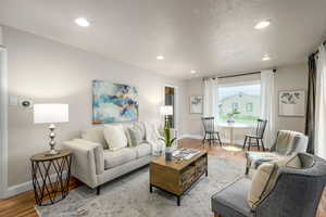 Living area featuring wood finished floors, a textured ceiling, and recessed lighting