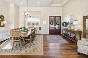 Dining space featuring french doors, dark wood-type flooring, and suspended lighting