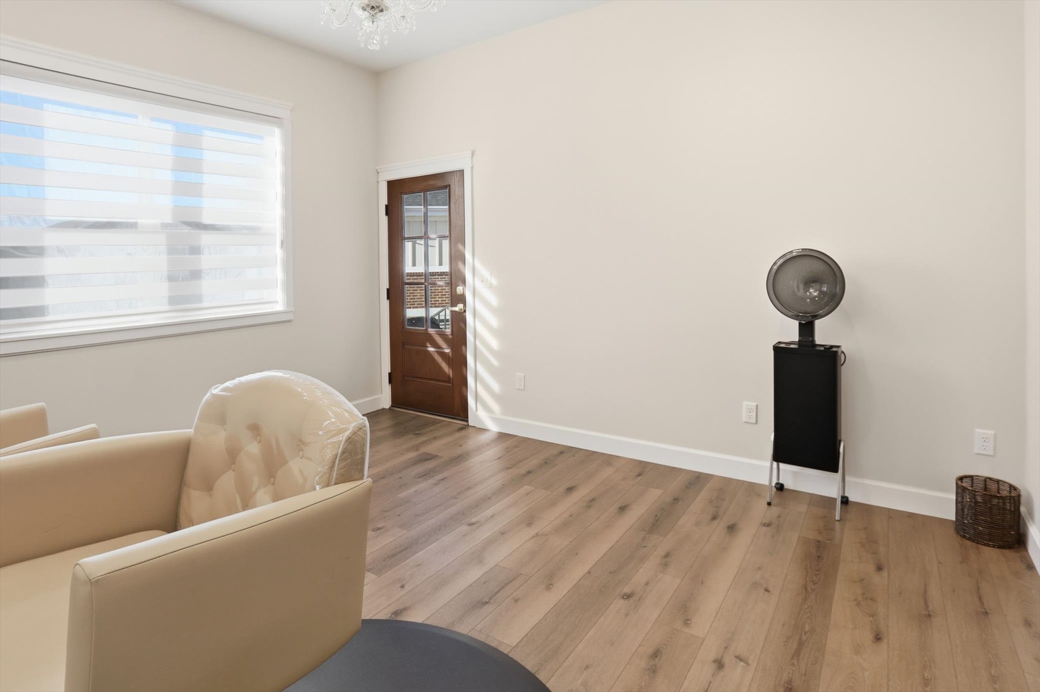 Sitting room with wood finished floors and suspended lighting