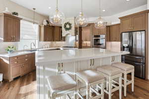 Kitchen featuring decorative backsplash, stainless steel appliances, a kitchen island, a kitchen bar, and dual tone cabinets
