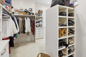 Walk in closet featuring light colored carpet