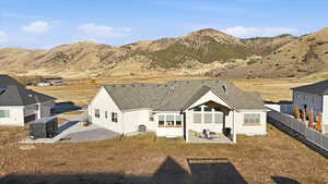 Back of property with a patio area, stucco siding, a mountain view, and roof with shingles