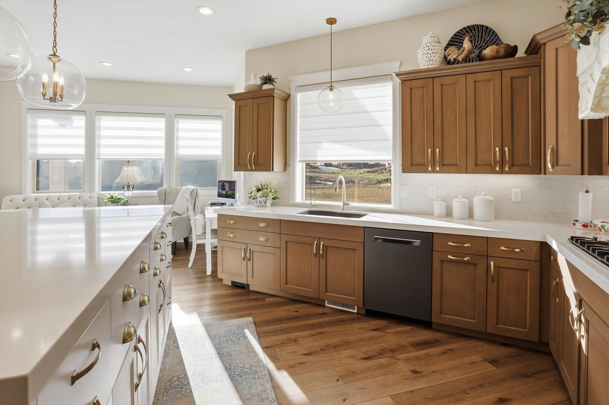 Kitchen with wood finish cabinetry, stainless steel dishwasher, dark wood finished floors, decorative backsplash, and light stone counters