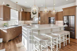 Dual tone kitchen featuring stainless steel appliances, a kitchen breakfast bar, a center island, two tone color scheme, and backsplash