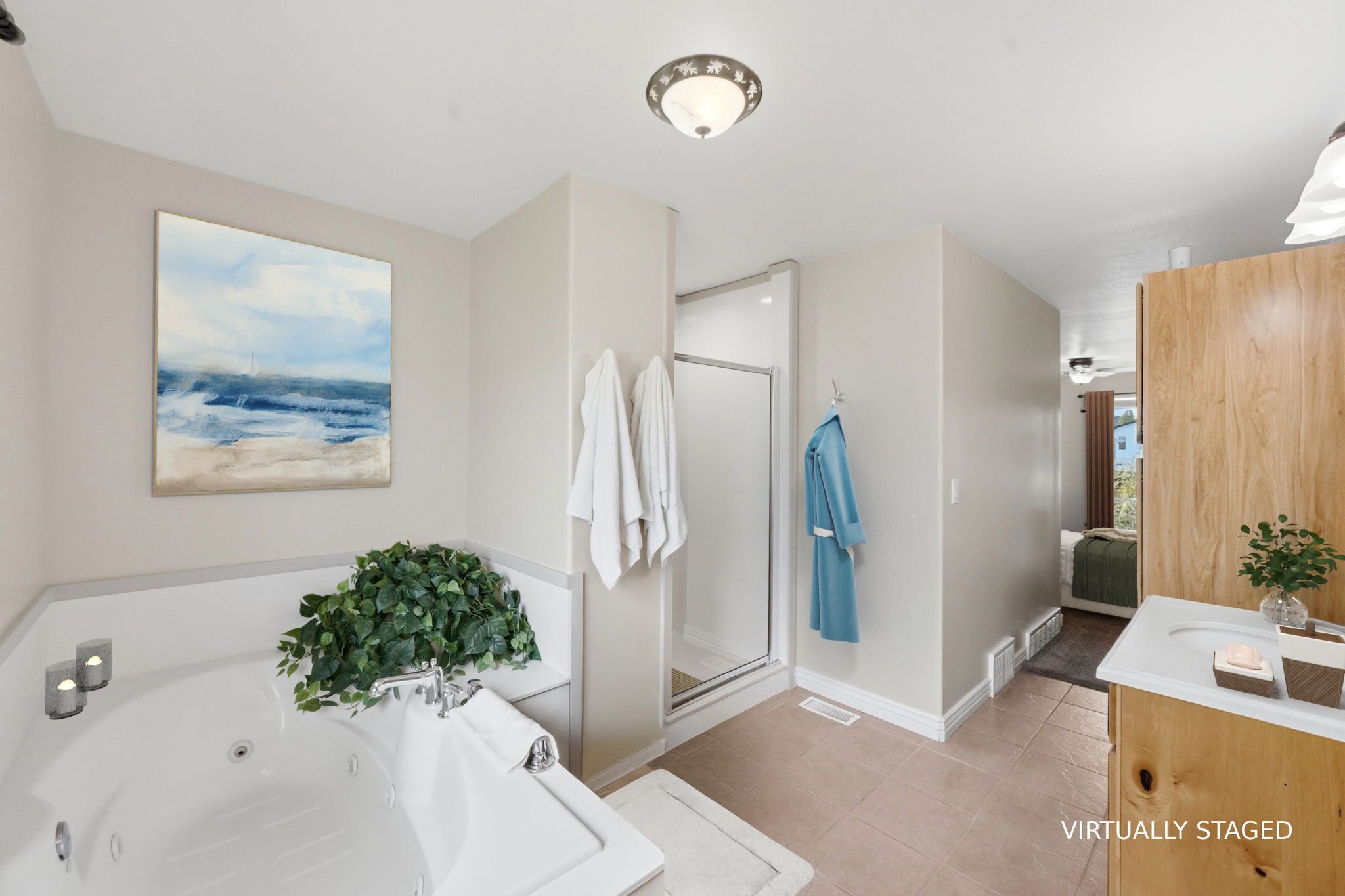 STAGED Ensuite bathroom featuring vanity, a tub with jets, a stall shower, and light tile patterned flooring