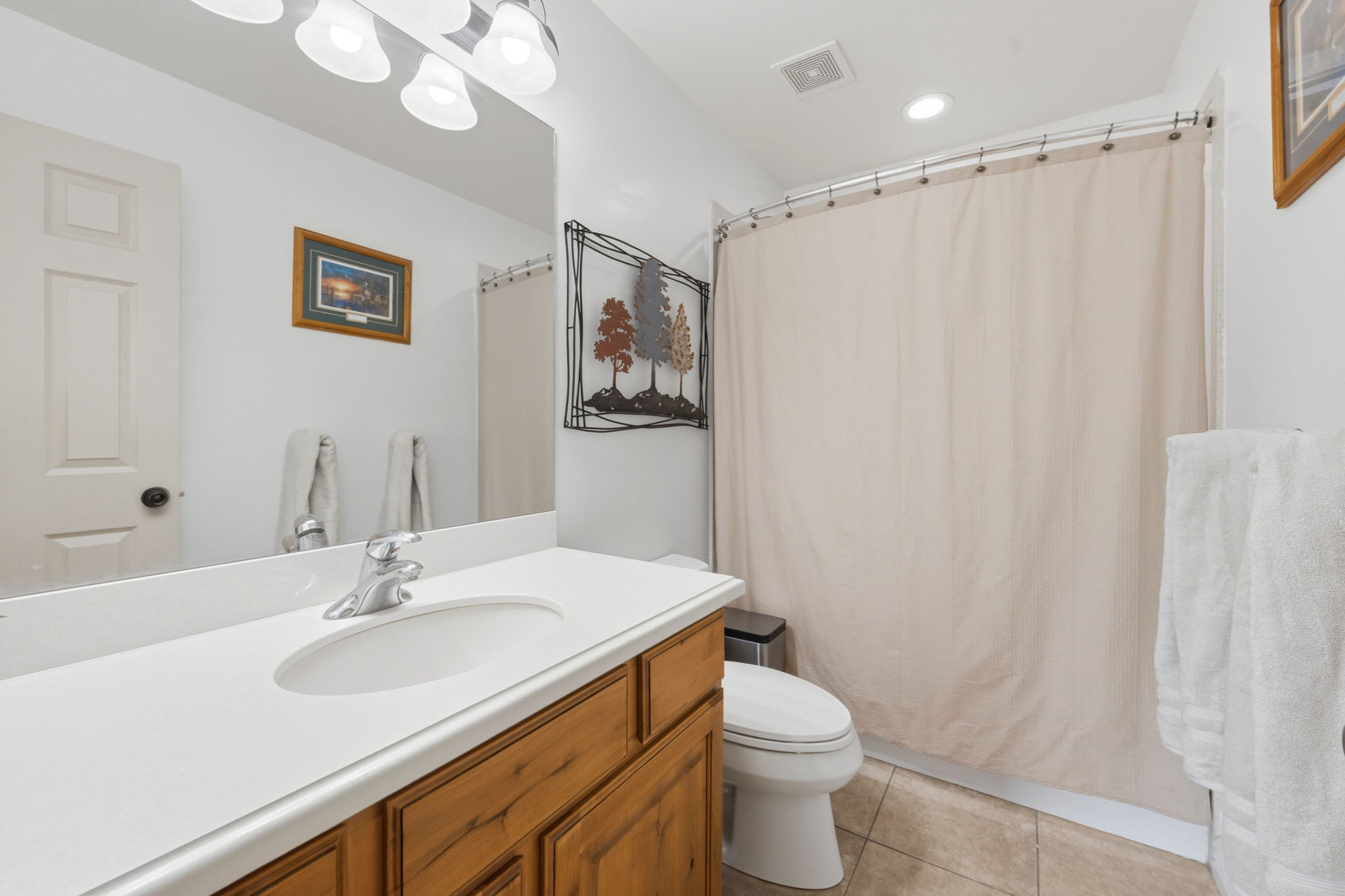Bathroom featuring vanity, light tile patterned flooring, and recessed lighting