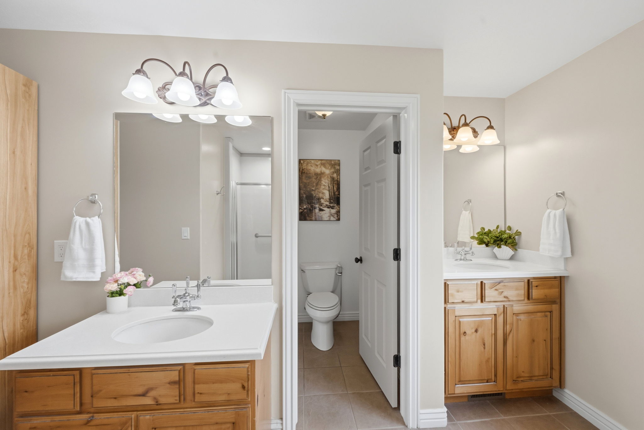 Ensuite Full bathroom featuring two vanities and light tile