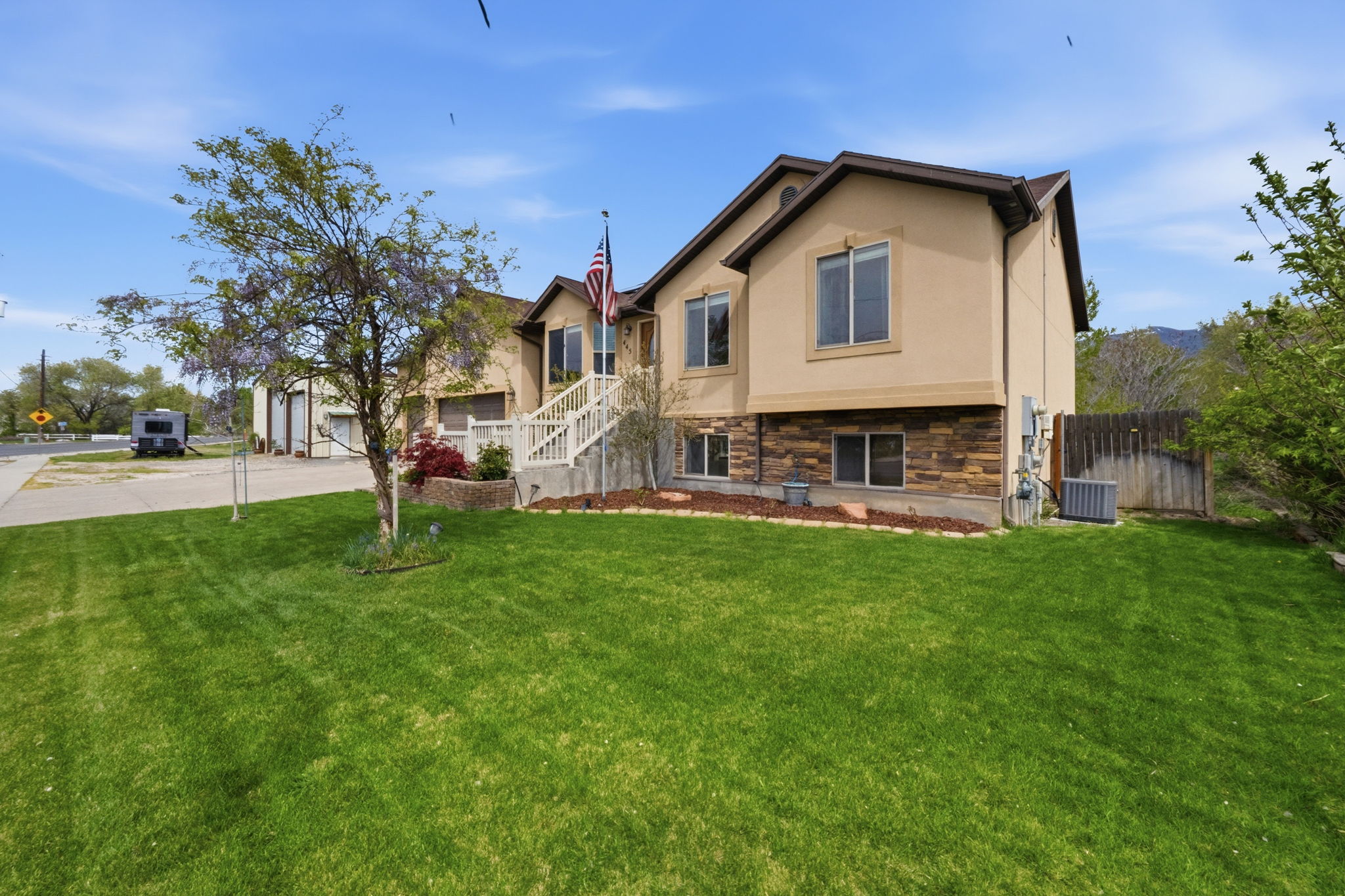 View of front of property with stone siding, stucco siding, and concrete driveway