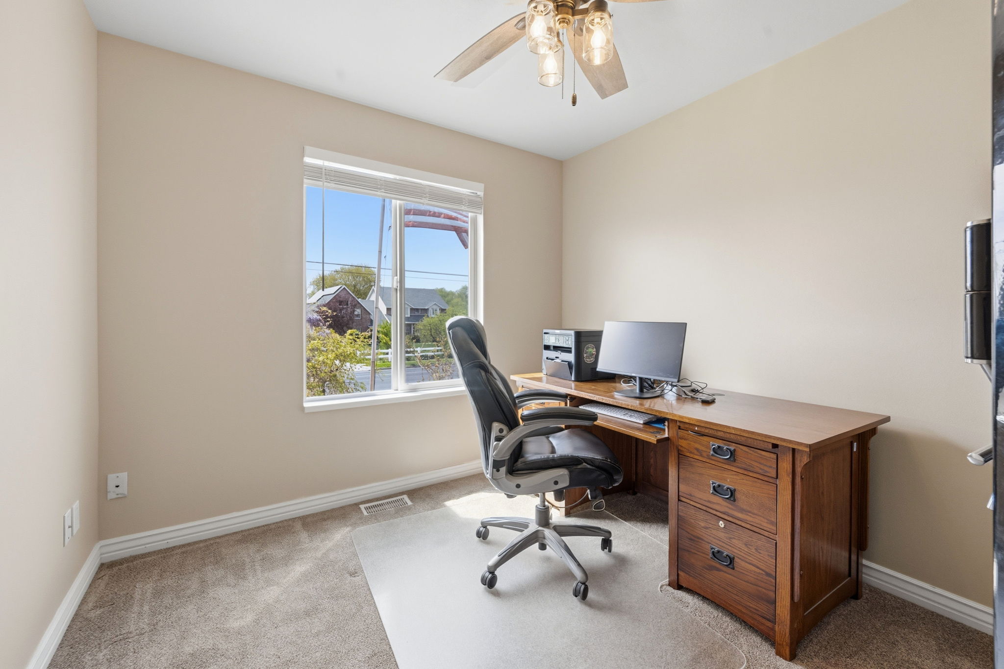 Second Bedroom on the main floor or Office with light colored carpet and a ceiling fan