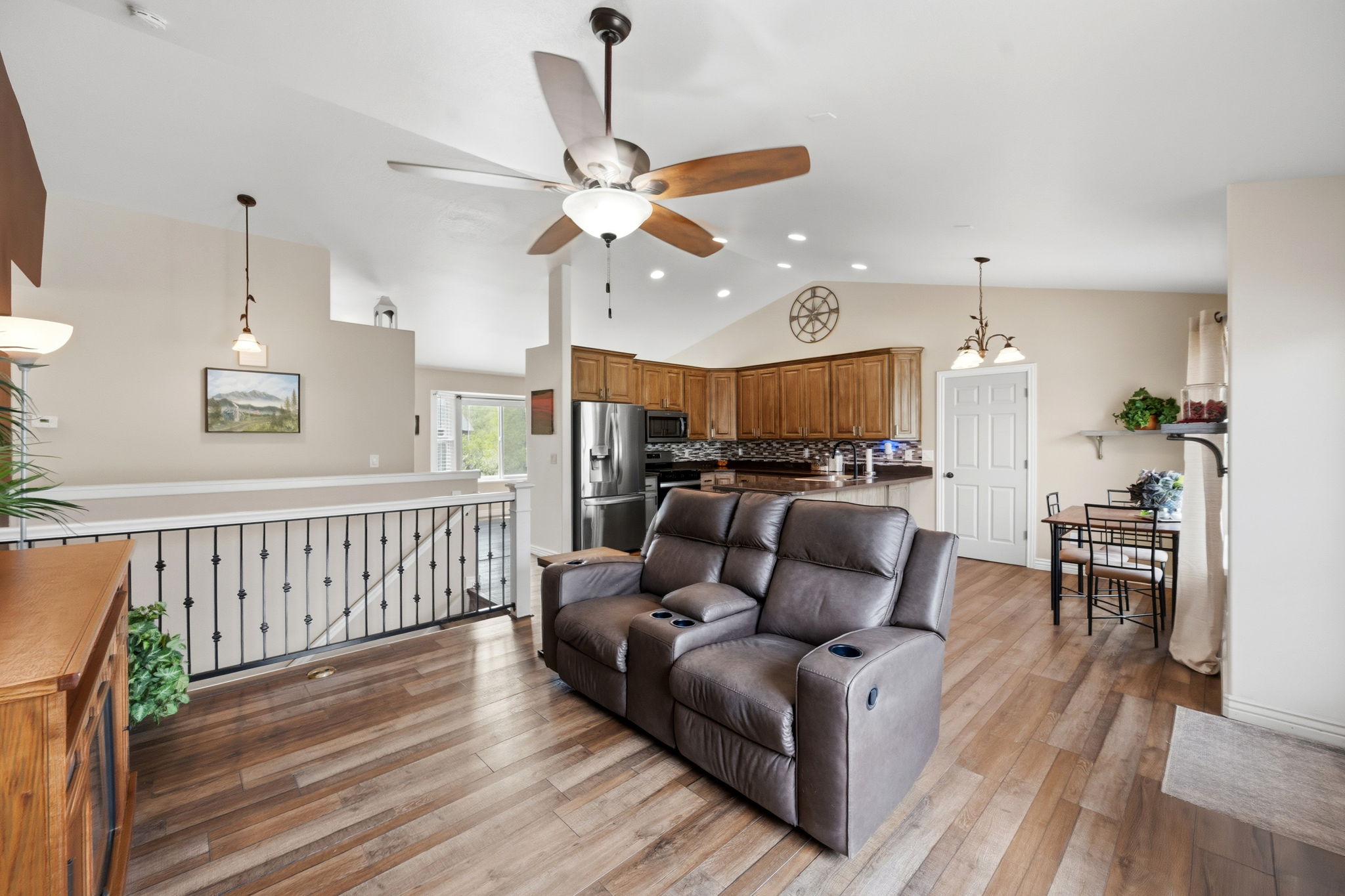 Family room with light wood-style floors, lofted ceiling, ceiling fan, and recessed lighting