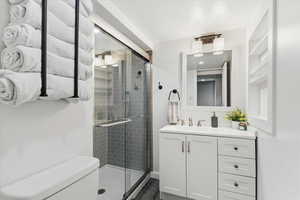 Bathroom featuring vanity, a stall shower, and dark wood-style floors